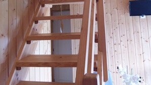 A wooden staircase with a handrail leading to an upper level.
