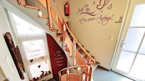 A wooden staircase with a handrail, a wall with decorative text, and a door with a window. - Apartment Near the Gondelbahn With Shared Pool (Hermagor-Pressegger See)