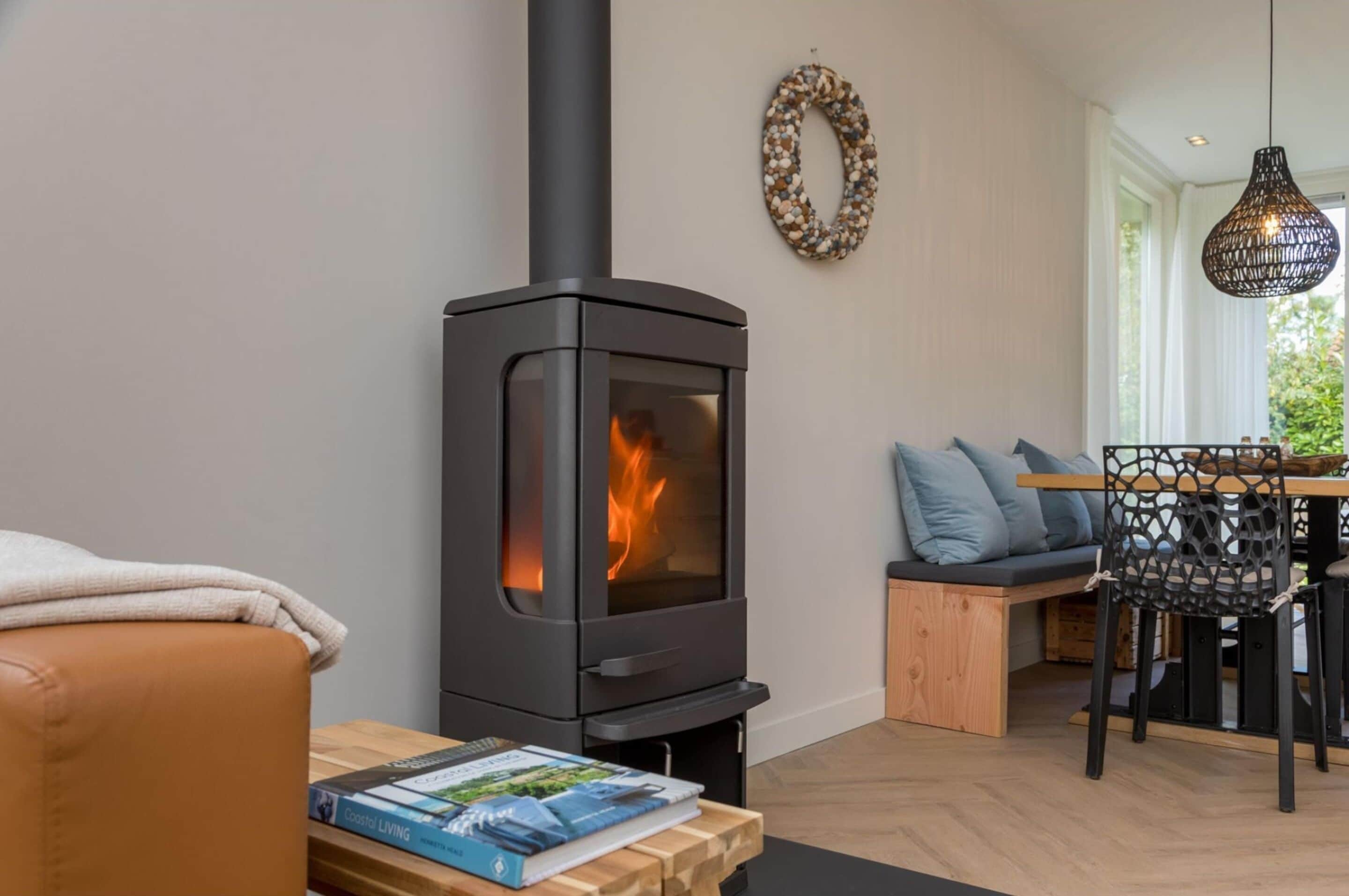 A cozy living room with a wood-burning stove, a dining area with a table and chairs, and a comfortable seating area.