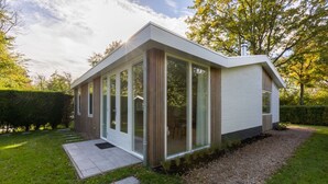 A modern house with large glass windows, a wooden exterior, and a well-maintained garden. - House in Oostkapelle Near Beach & Sauna (Oostkapelle)