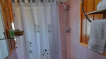 Een badkamer met toilet, wastafel, douche en een handdoekrek.