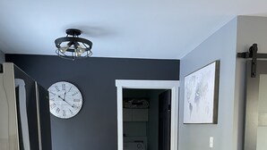 A modern kitchen with a built-in oven, a dining area with a table and chairs, and a hallway leading to another room.