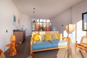 A modern living room with a sofa, a coffee table, and a lamp.