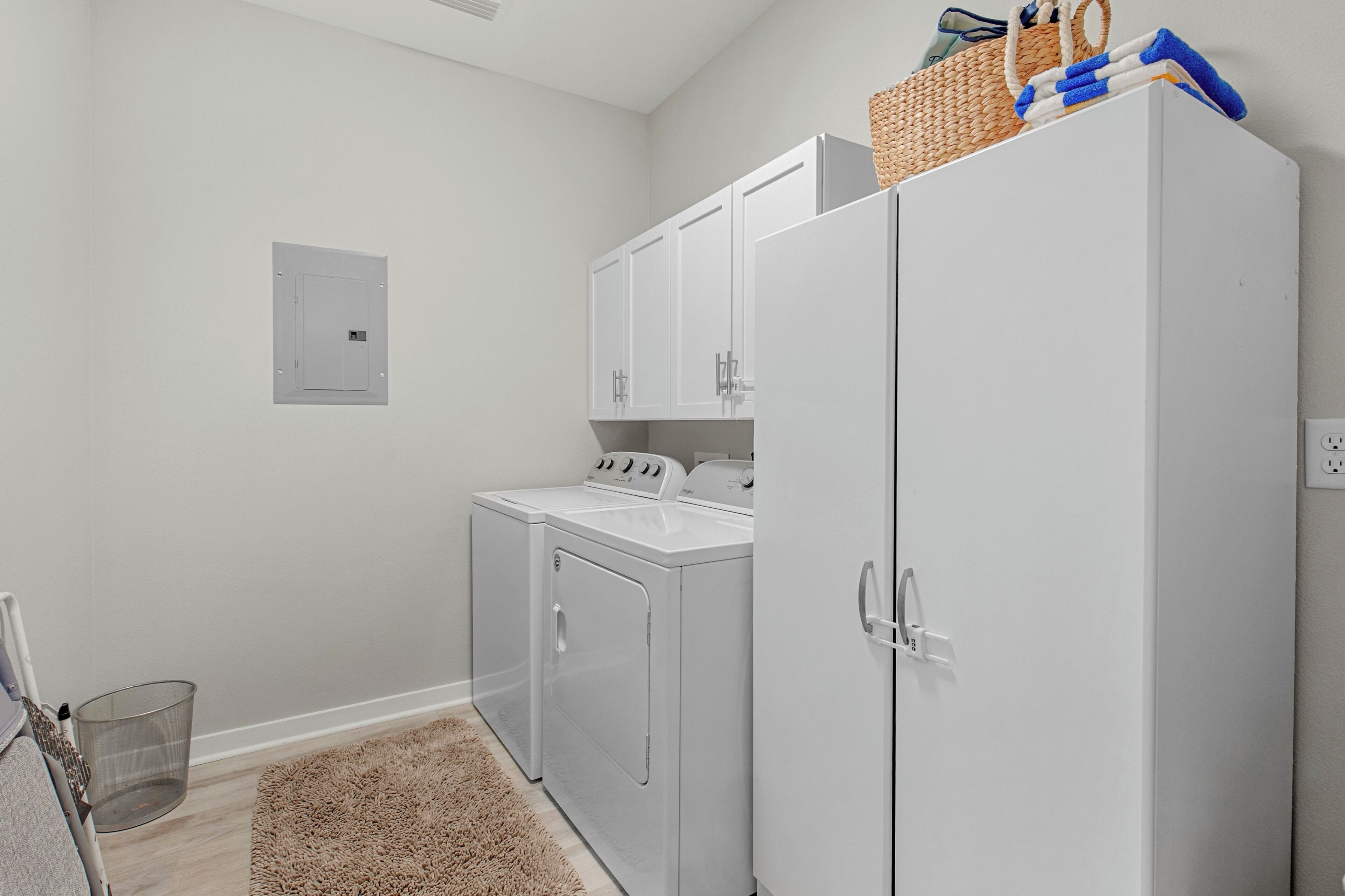 A laundry room with a washing machine, dryer, and a cabinet.