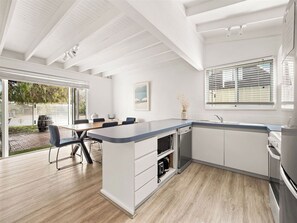 A modern kitchen with a large island, built-in appliances, and a dining area with a view.