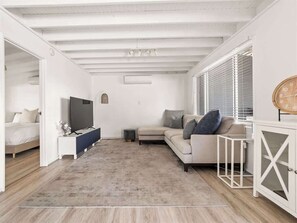 A modern living room with a sofa, TV, and a cabinet.