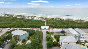 Vista aérea de una zona costera con edificios, una playa y un muelle.