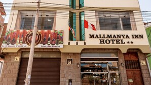 Un edificio de varios pisos con un letrero que indica Hotel Mallmanya Inn.
