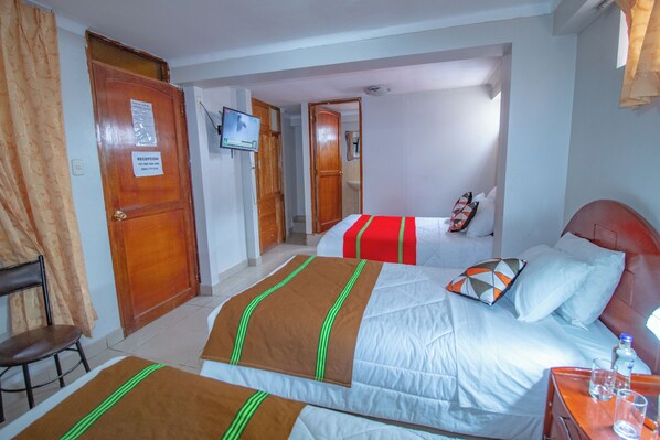 A hotel room with two beds, a television, and a reception sign. - ALO INKA HOTEL (Cusco)