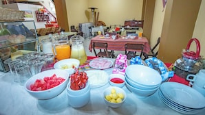 Una barra de buffet con diversos alimentos y utensilios.