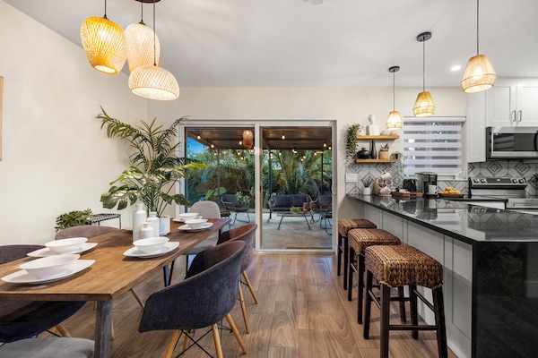 Dining table with extra seating in large kitchen island facing lush patio
