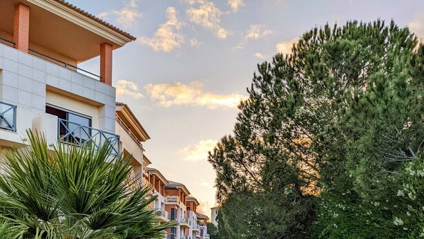 A pathway flanked by well-maintained greenery and a row of modern buildings with balconies. - Modern & Spacious Flat with Pool close to Oura (Albufeira)