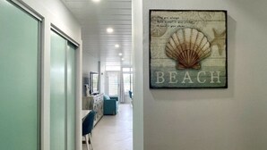 En gang med et billede af en sød musling og ordet "BEACH" på væggen.