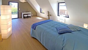 A bedroom with a bed, a desk, and a chair. There is a large window providing natural light. - KERPI, Very spacious house, 3 minutes' walk from Kerbourgnec beach (Saint-Pierre-Quiberon)