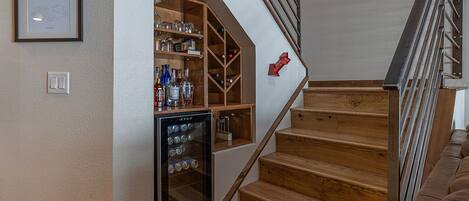 A wooden staircase with a built-in wine fridge and shelves.