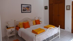 A bedroom with a bed, nightstands, a wardrobe, and a painting on the wall. - Cozy studio in the garden with terrace (Lagoa / Porches)