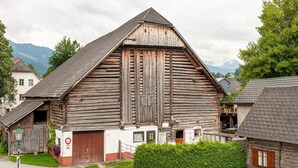 A traditional wooden building with a steeply pitched roof, a large wooden door, and a small window. - Apartment Near ski Area in Groebming (Groebming)