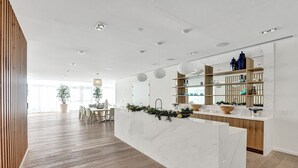 A modern kitchen with a marble countertop, wooden cabinets, and a built-in island.