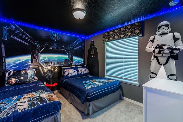 A bedroom with a space-themed design, including a bed with a space shuttle print, a wall mural of a space scene, and a Stormtrooper figure. - Special Offer- 10BR/8BA Windsor Island, Private pool 2017LC (Davenport)