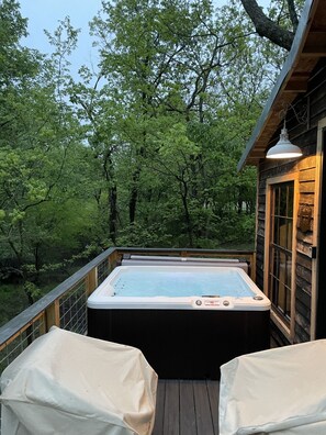 A hot tub on a wooden deck with a view of a forest. - Fun & Magical Treehouse (Coweta)