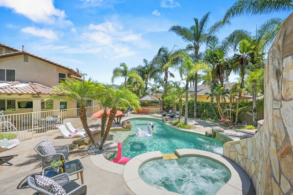 A pool area with lounge chairs, a hot tub, and palm trees. - Villa Paradiso (El Cajon)