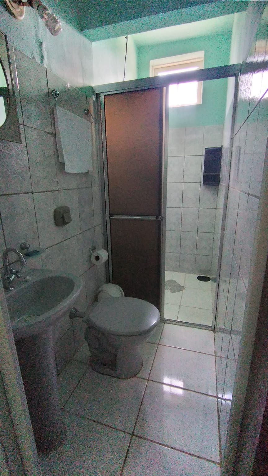 Een badkamer met toilet, wastafel en douchehoek.
