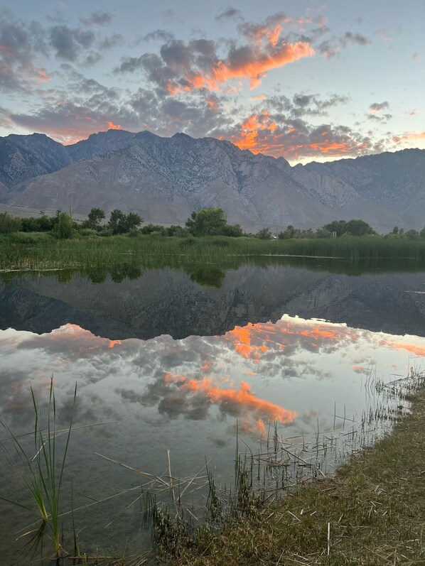 Un lago tranquillo che riflette il cielo e le montagne.
