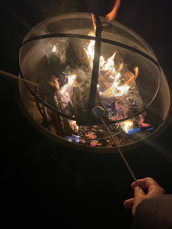 Una fogata con un recinto de malla metálica.