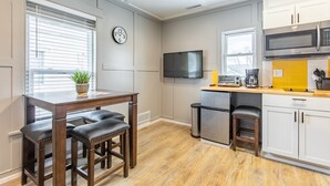 A modern kitchen with a dining area, built-in appliances, and a flat-screen TV.
