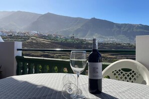 A table with a bottle of wine and a glass on a balcony overlooking a mountainous landscape. - Sunset view in La Romantica, 3 (Los Realejos)