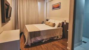 Ein Hotelzimmer mit Bett, Nachttisch und Blick auf den Flur.
