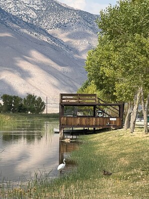 Une structure en bois au bord dâun lac, avec une montagne en arriĂšre-plan.