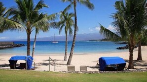 A beach with palm trees, a clear blue sky, and a calm sea. - Golf Villas at Mauna Lani Q22 -1,460 sq Beach Club Access (Waimea)