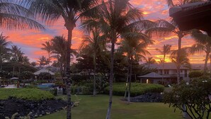 A tropical resort with palm trees, a swimming pool, and a building with a thatched roof. - Golf Villas at Mauna Lani Q22 -1,460 sq Beach Club Access (Waimea)