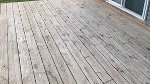 Eine Holzterrasse mit einer Schiebetür zu einem überdachten Bereich.