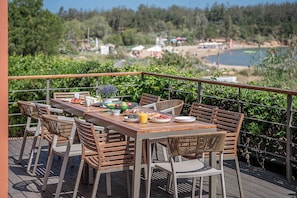 Enjoy a meal on the deck overlooking the serene lake and sandy beach.