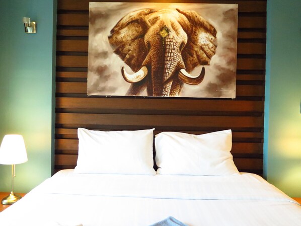 Relax in comfort with a large bed and a beautiful elephant artwork above.