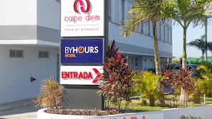 A hotel entrance with signs for 'Carpe Diem' and 'ByHours Hotel' and an 'Entrada' sign with an arrow. - Hotel ByHours Circunvalar (Barranquilla)