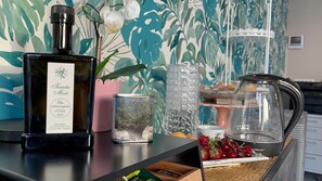 Una zona de bar con una botella de aceite de oliva, un recipiente y una bandeja de frutas.