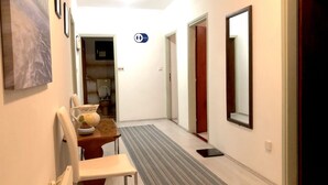 Ein Flur mit Essbereich, Badezimmer und Spiegel.