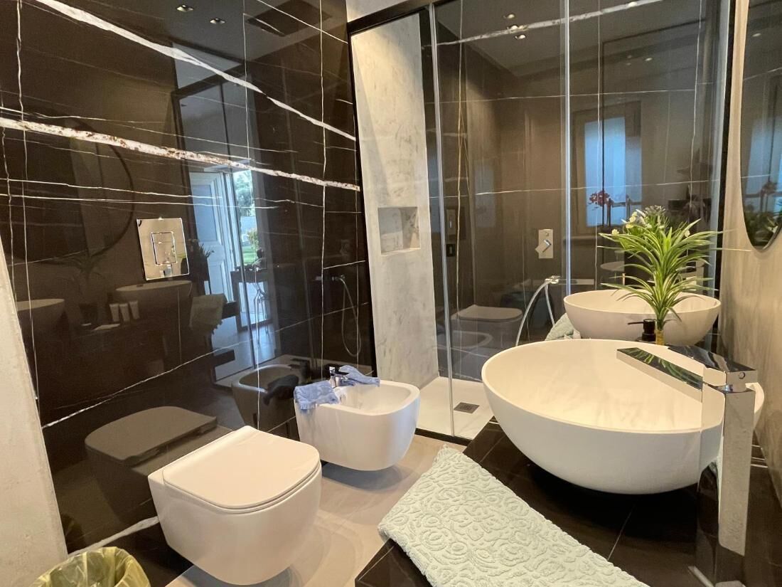 Un baño moderno con una bañera grande, un inodoro separado y un bidé.