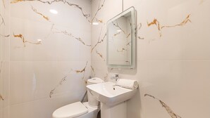 Ein Badezimmer mit Toilette, Waschbecken und Spiegel.