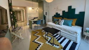 Una sala de estar moderna con sofá, comedor y cocina.