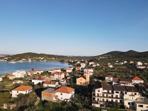 A coastal town with buildings along the waterfront, a clear sky, and hills in the background. - Nar Apartment A3 - With sea View Balcony (Pasman)