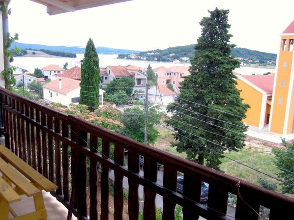 A balcony with a view of a residential area, including houses and a church. - Nar Apartment A3 - With sea View Balcony (Pasman)