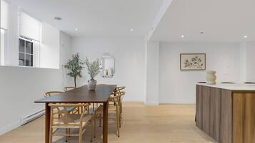 Un comedor moderno con una mesa y sillas de madera, una planta en maceta y una decoración minimalista.