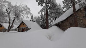 Schneebedeckte Landschaft mit einem Steinhaus und einem gelben Gebäude.