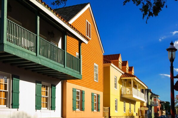 A row of colorful buildings with balconies and windows.