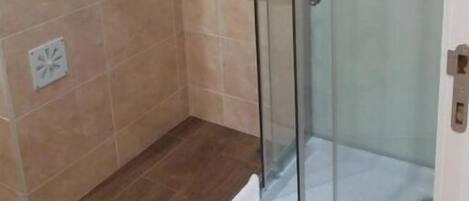 Een douche, handdoeken, zeep, shampoo