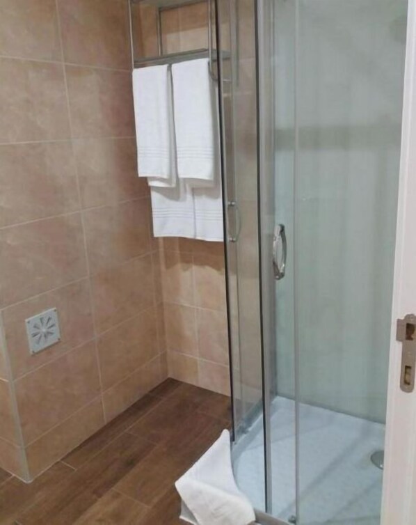 Een douche, handdoeken, zeep, shampoo